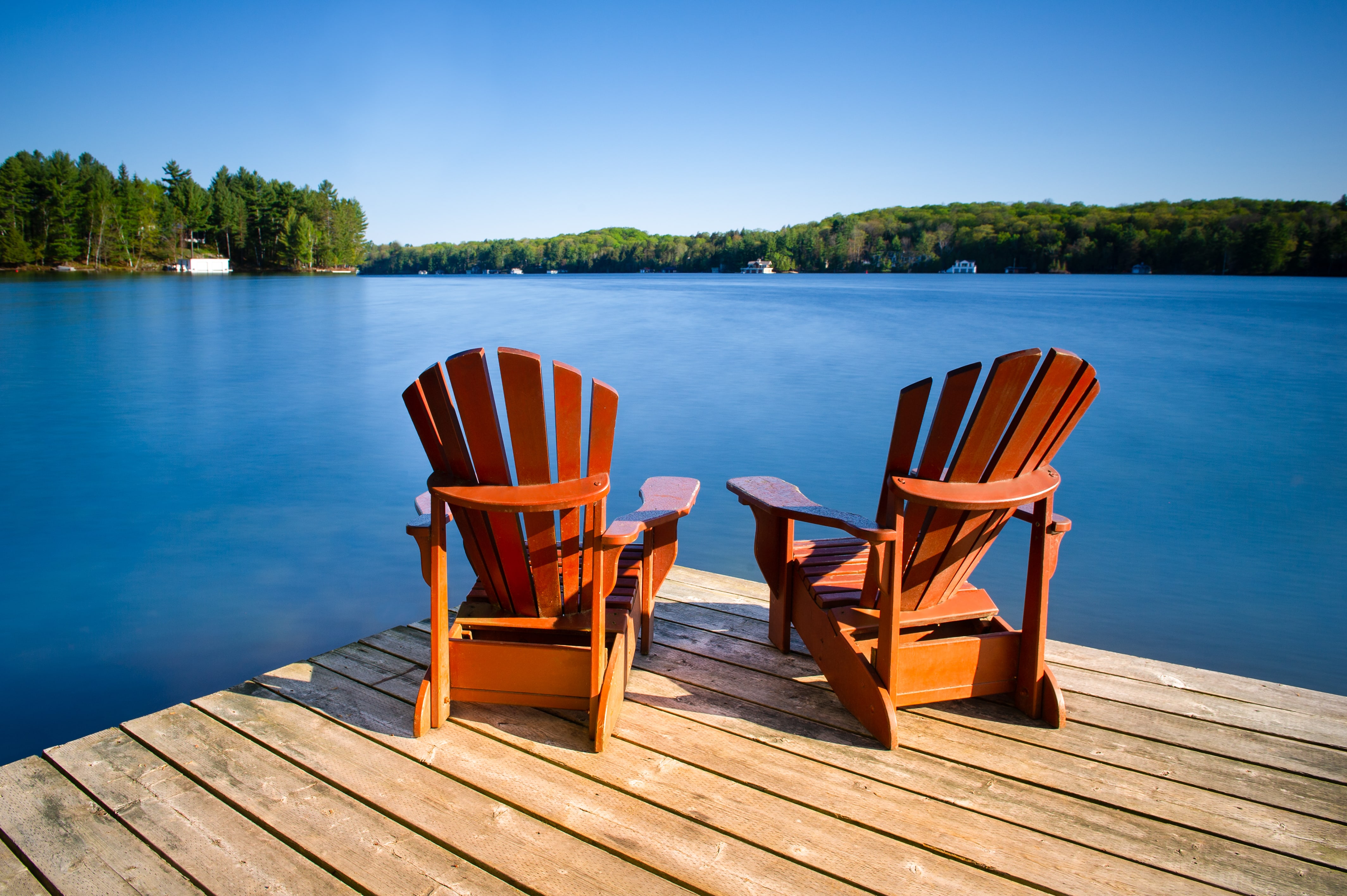 Adirondack chairs overlooking a lake.